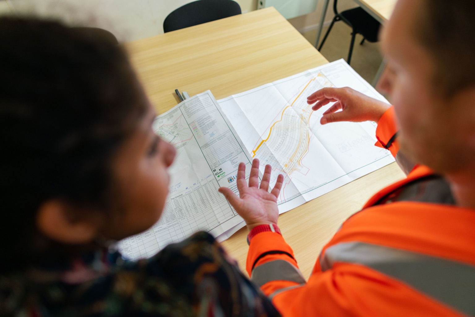 Construction professionals coordinating work from a marked-up site plan